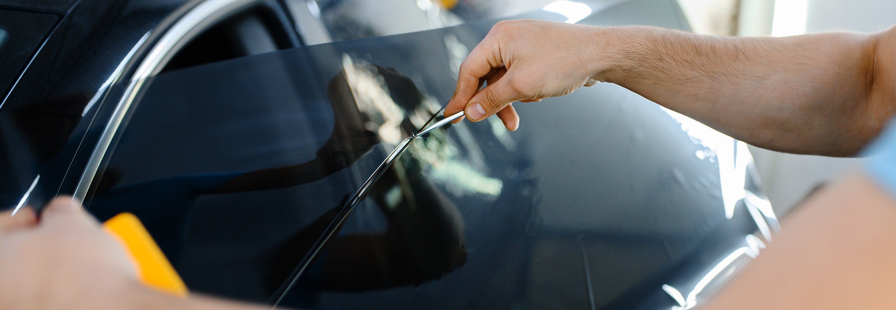 Window tinting on a car in Top Auto Glass workshop.
